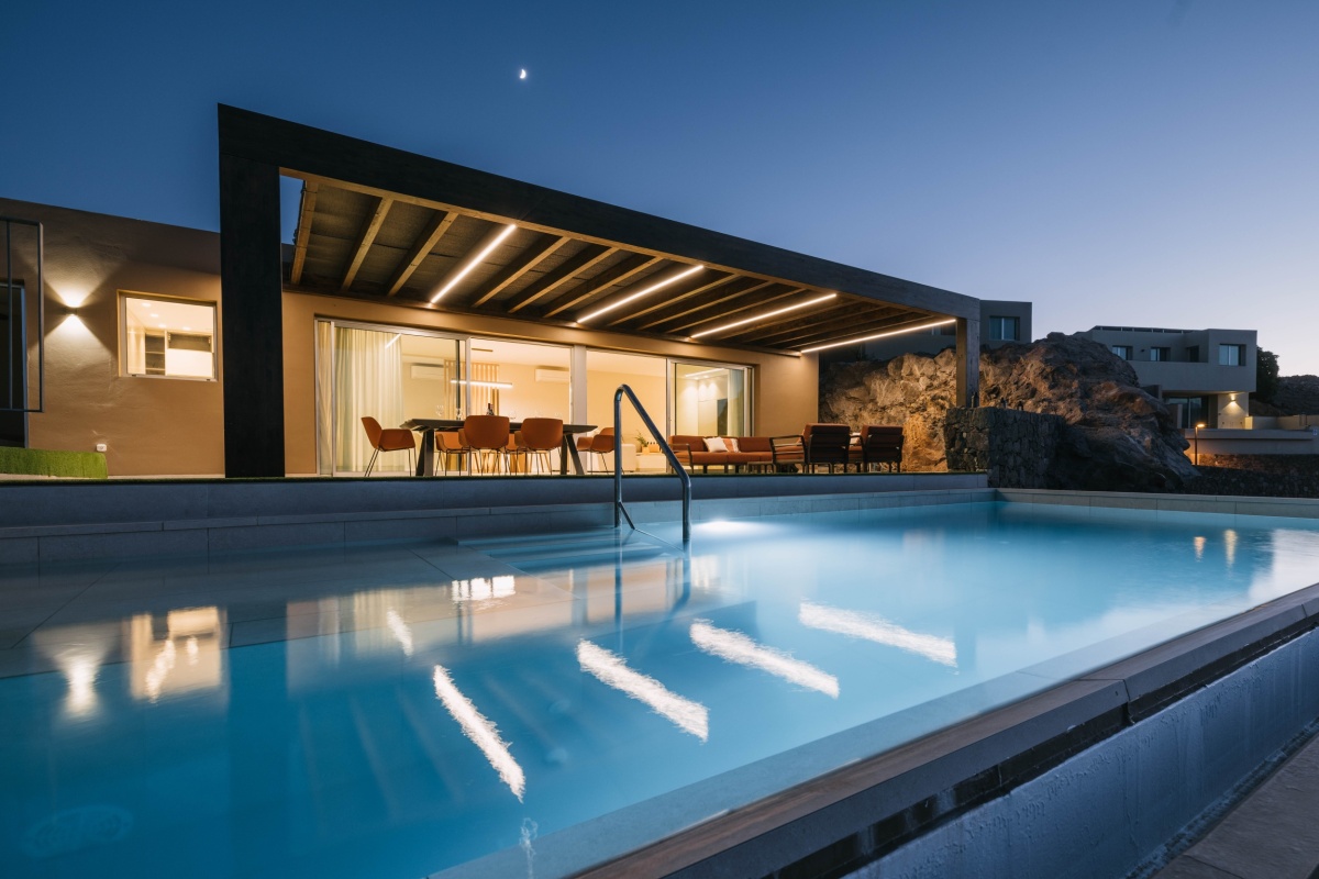 Modern villa in Salobre Golf, Gran Canaria, with swimming pool illuminated at sunset.