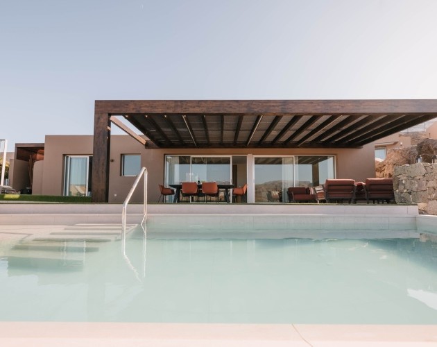 Villa moderna en Salobre Golf, Gran Canaria, con piscina iluminada al atardecer.