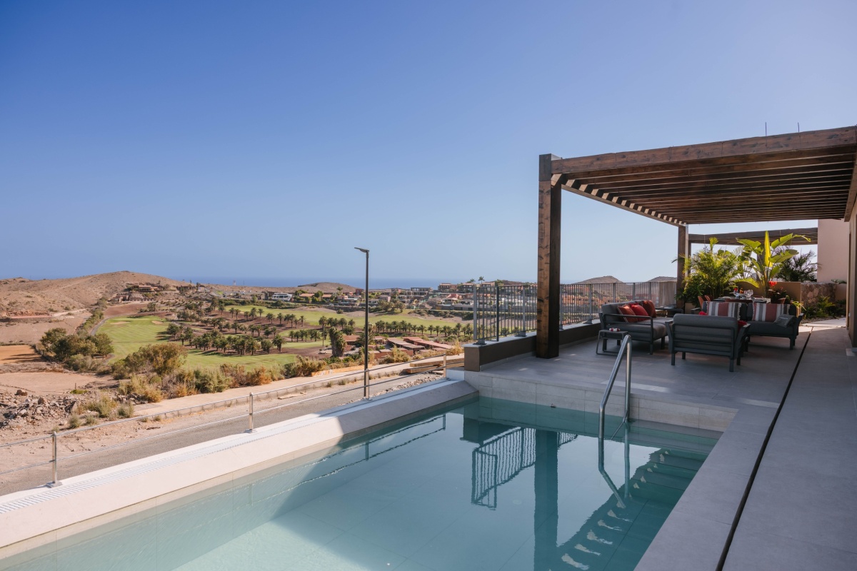 Pool area and patio overlooking the mountains in the Villa of Salobre Homes, Salobre Golf, Gran Canaria.