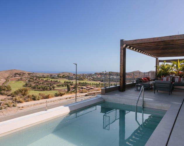 Área de piscina y patio con vista a las montañas en la Villa de Salobre Homes, Salobre Golf, Gran Canaria.