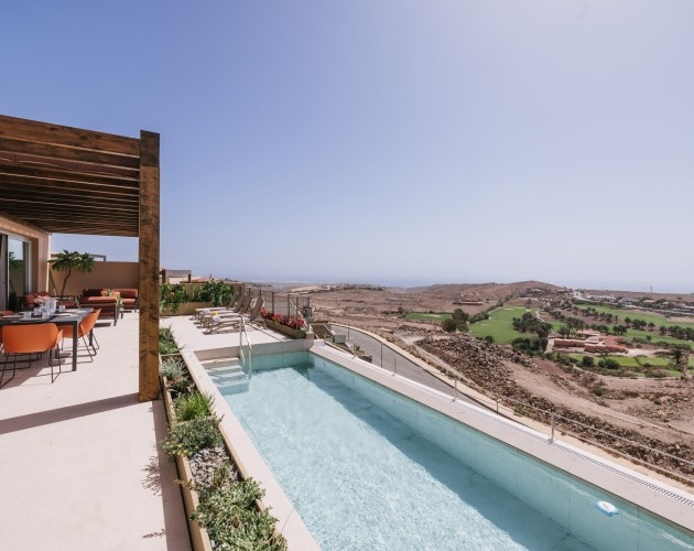 Área de piscina y patio con vista a las montañas en la Villa de Salobre Homes, Salobre Golf, Gran Canaria.