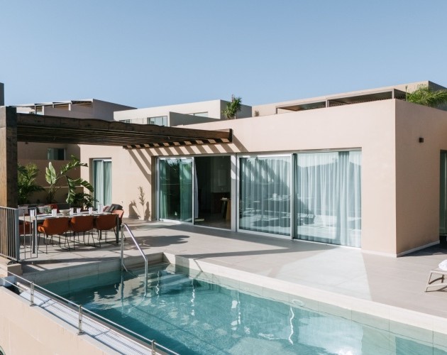 Vista de una piscina y patio con vista al campo de golf en la Villa del complejo en Salobre Golf, Gran Canaria.